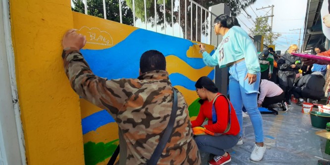 Padres de familia pintando en las paredes del colegio IED República de Panamá